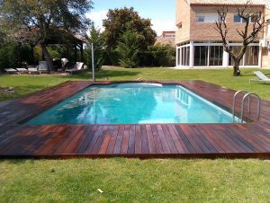 Tarima de madera de ipe en jardin con piscina
